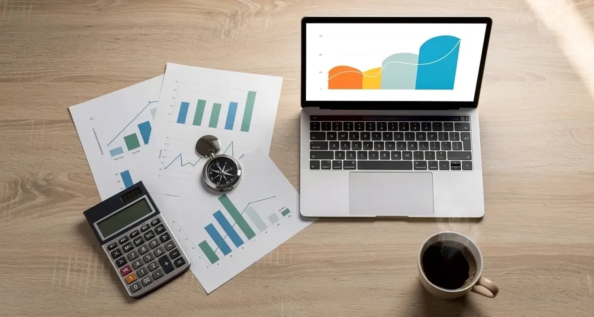 Desk flat lay with a laptop showing a revenue growth chart, printed forecast charts, a compass, and a calculator, representing sales forecasting methods